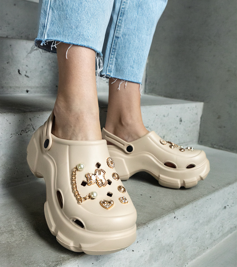 Smėlio spalvos uždari klumpiai ant platformos su papuošimais Aria